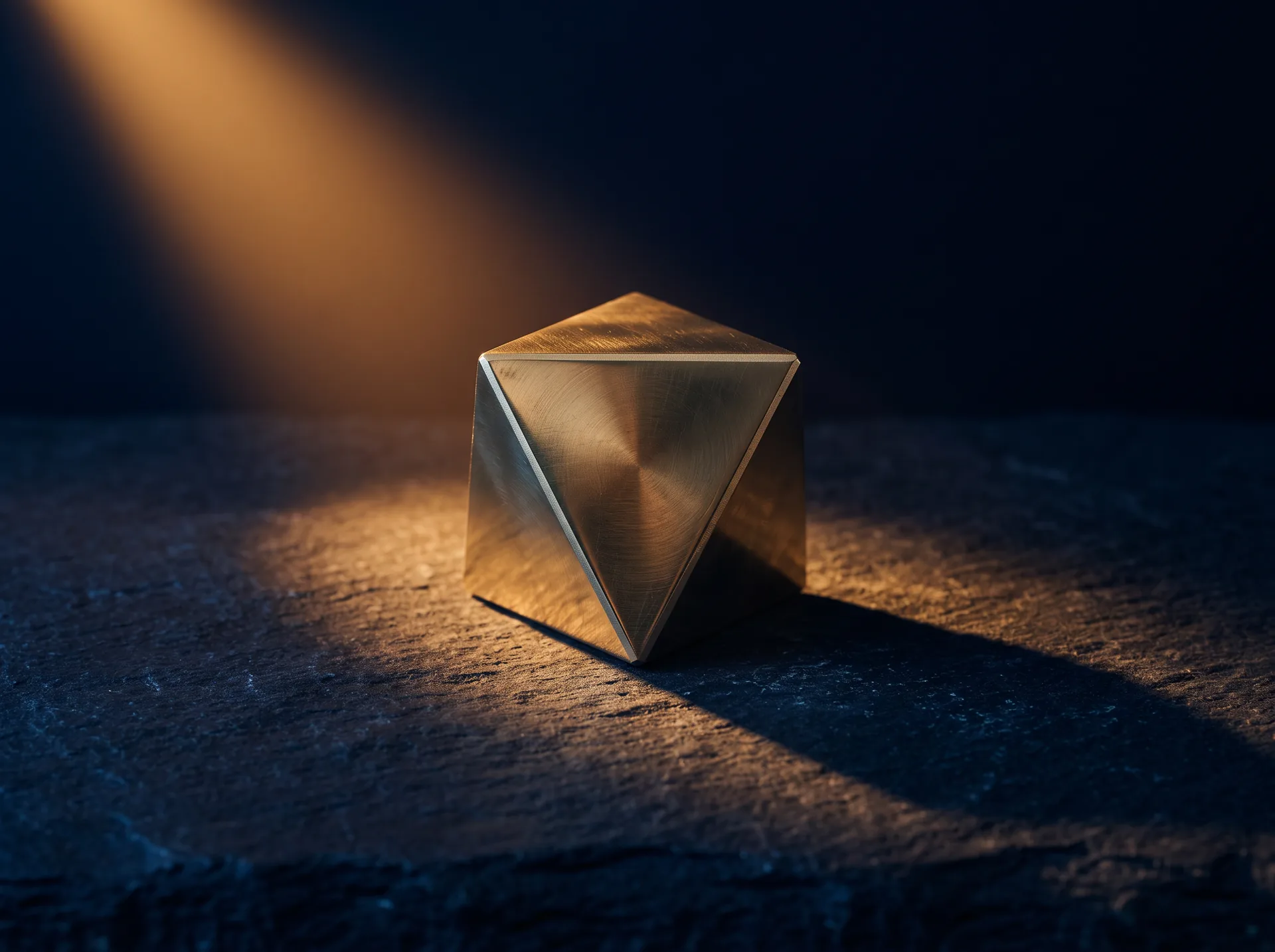 A brass geometric solid lit by an amber beam on dark stone